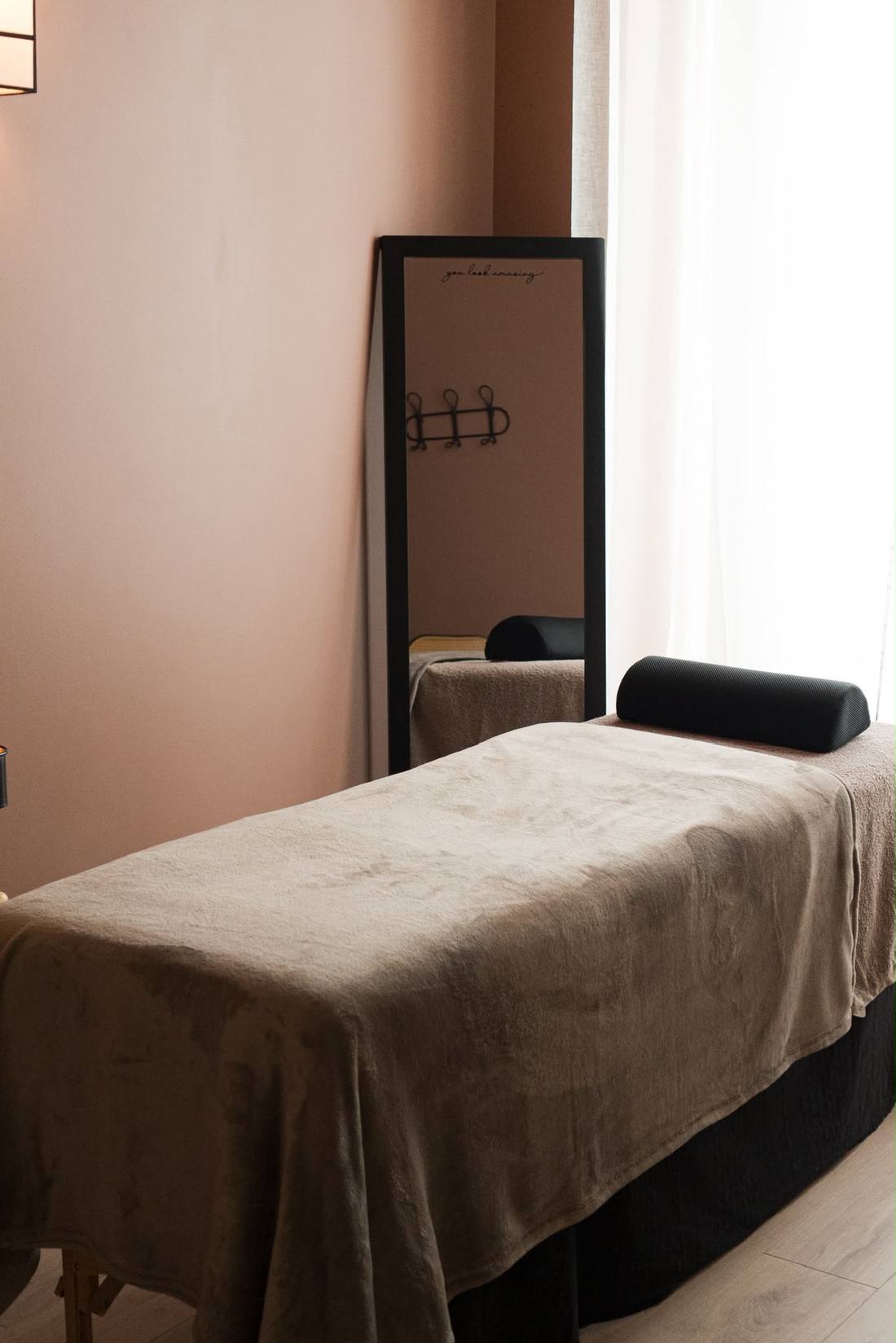 Table de soin drapée face au miroir, baignée par la lumière du voilage